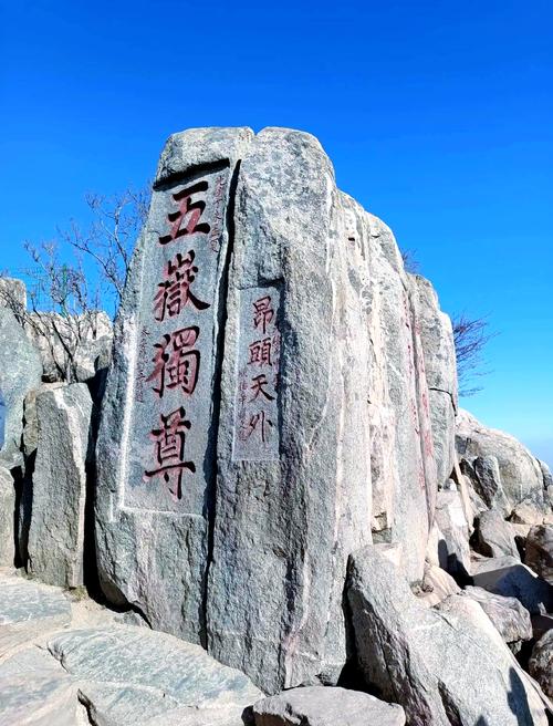 男子攀爬五岳独尊石,游客爬上五岳独尊石刻拍照